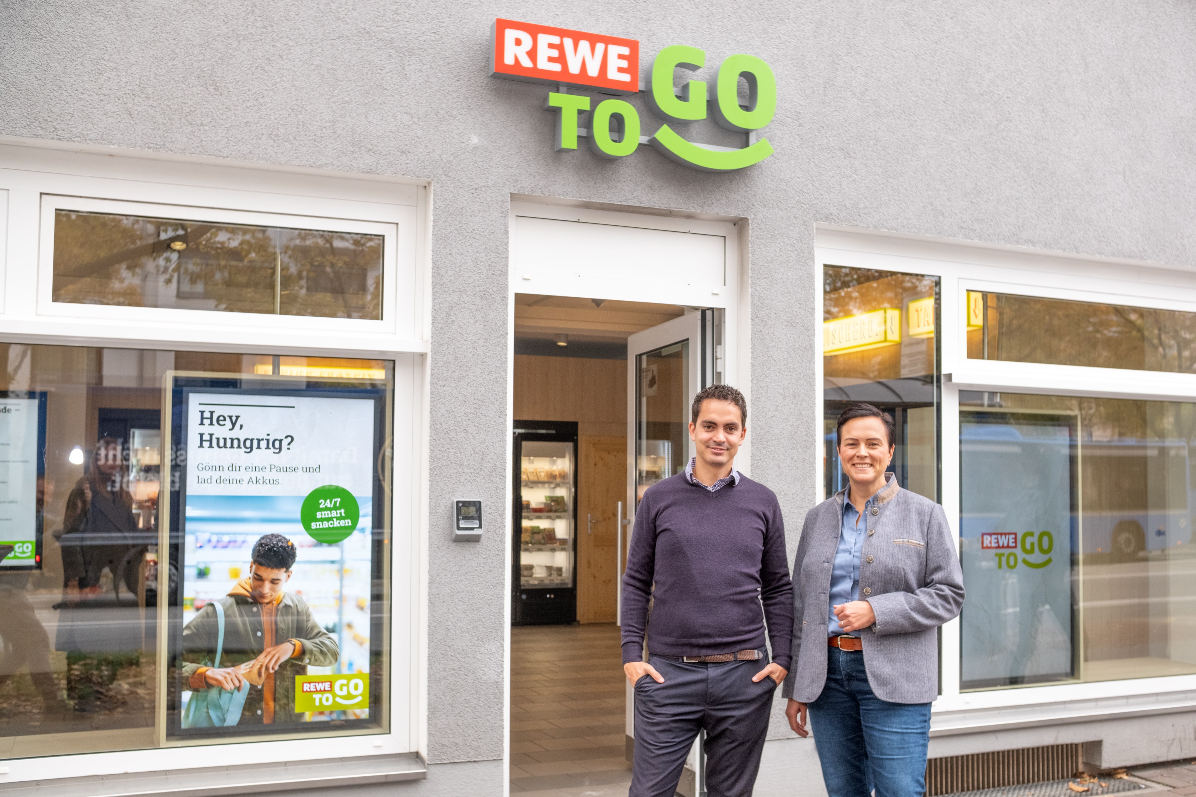 Vor dem neuen kassenlosen REWE To Go in München-Sendling (von links): Andrea Günther (Regionalleitung München, Vonovia) und Christian Schulz (Senior Manager Pilotprojekte, Lekkerland).